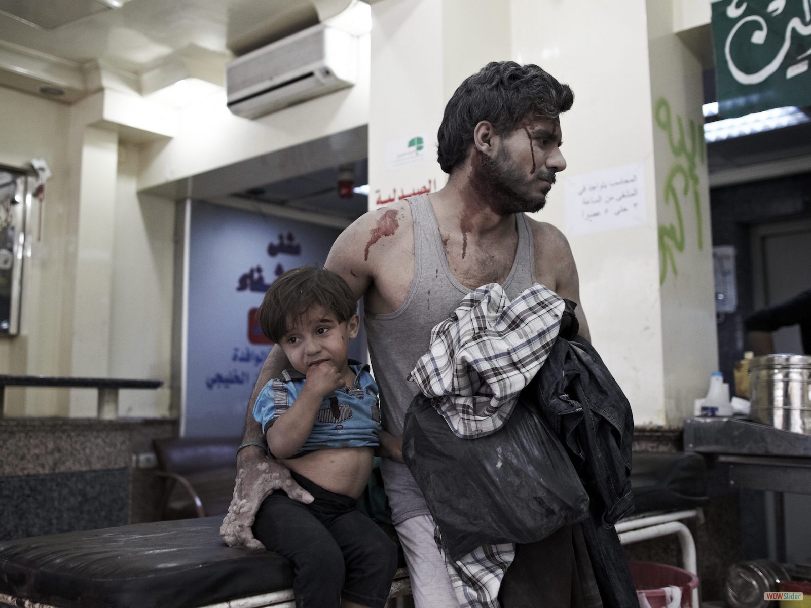 Après une attaque aérienne, un père et son fils attendent d’être soignés dans un des derniers hôpitaux encore debout à Alep.
<br><i><b>

A father and son after an air attack, waiting for medical treatment in one of the last hospitals still standing in Aleppo.
</b></i><br><i>© Sebastiano Tomada - Sipa Press - 2013</i>
