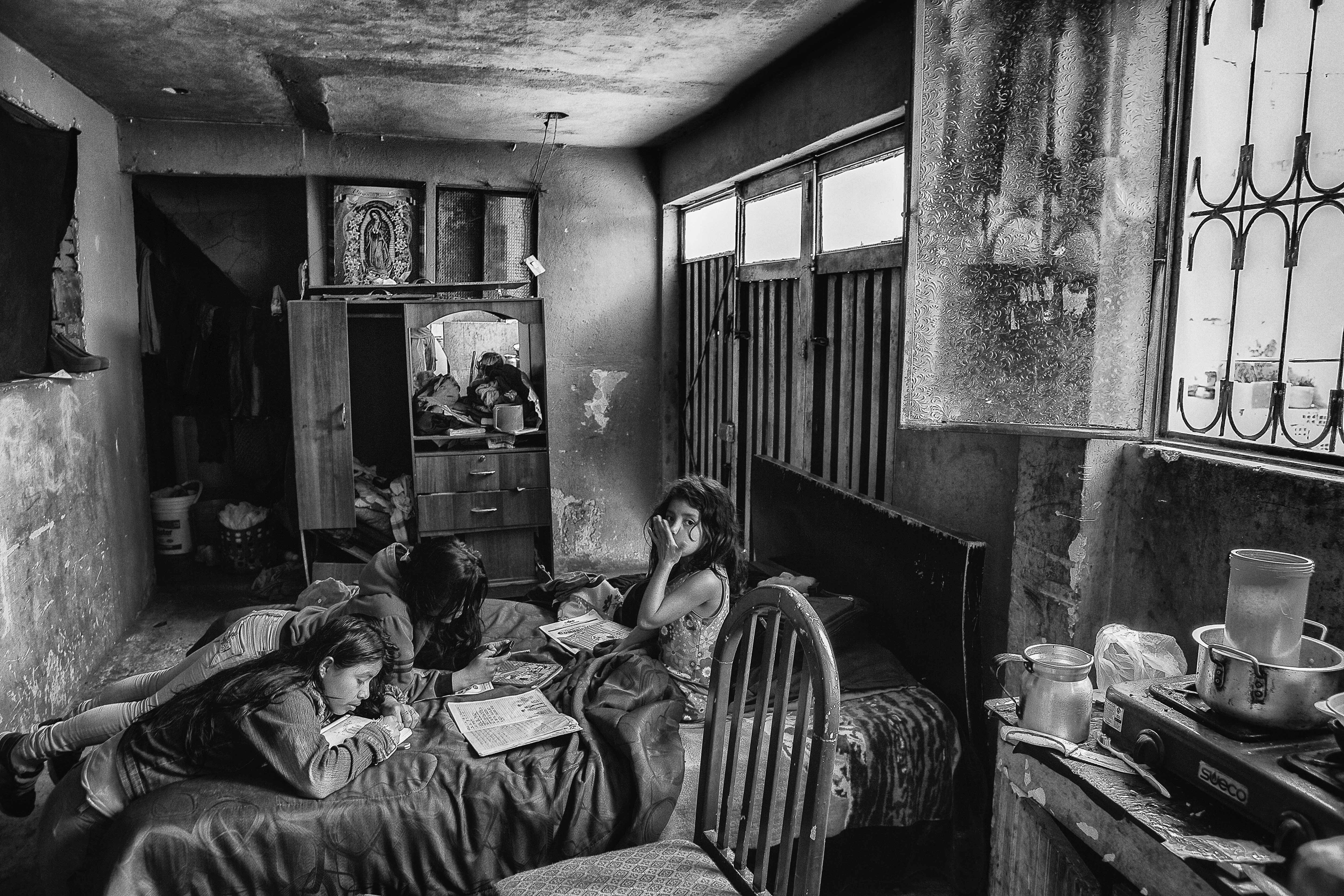 Angela (à droite) et ses sœurs Marcela et Angy font leurs devoirs dans une maison louée où vivent onze personnes. Marcela, Angy, leurs parents et leur frère Edinson étaient tous membres des FARC. Soacha, Bogota, juin 2015.
Angela (R) and her sisters Marcela and Angy doing their homework in the rented house where eleven people live. Marcela, Angy, their father, mother and brother Edinson were all members of the FARC. Soacha, Bogotá, June 2015.