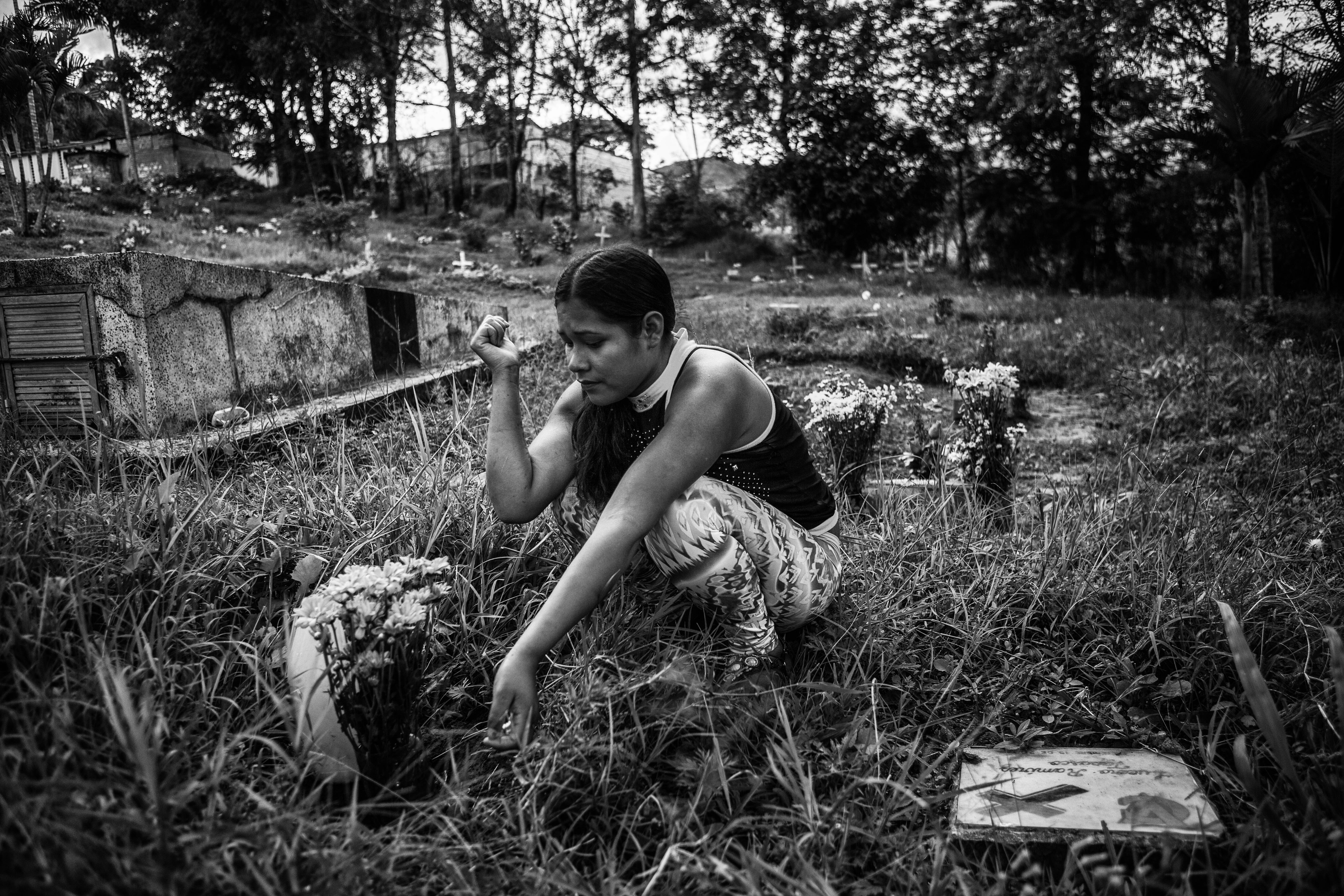 Melida (20 ans) et sa fille de 9 mois dans leur maison. Melida a été recrutée à l’âge de 9 ans par trois membres des FARC qui l’ont attirée en lui promettant des repas. Caldas, avril 2016.<br><i><b>
Melida (20) visiting the unmarked grave of her cousin Leila Fabiana who was also a child FARC recruit. They were reunited in a support center for demobilized child soldiers, but Leila committed suicide shortly after leaving the center. Caldas, Colombia, April 2016.
</b></i>
