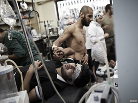  <p class='fr'>
	Un combattant de l’ASL tenant la main d’un camarade blessé, à l’hôpital Dar al-Shifa.
	</p> <p class='en'>
	A Free Syrian Army fighter holding the hand of a wounded comrade at Dar al-Shifa hospital.

	</p>