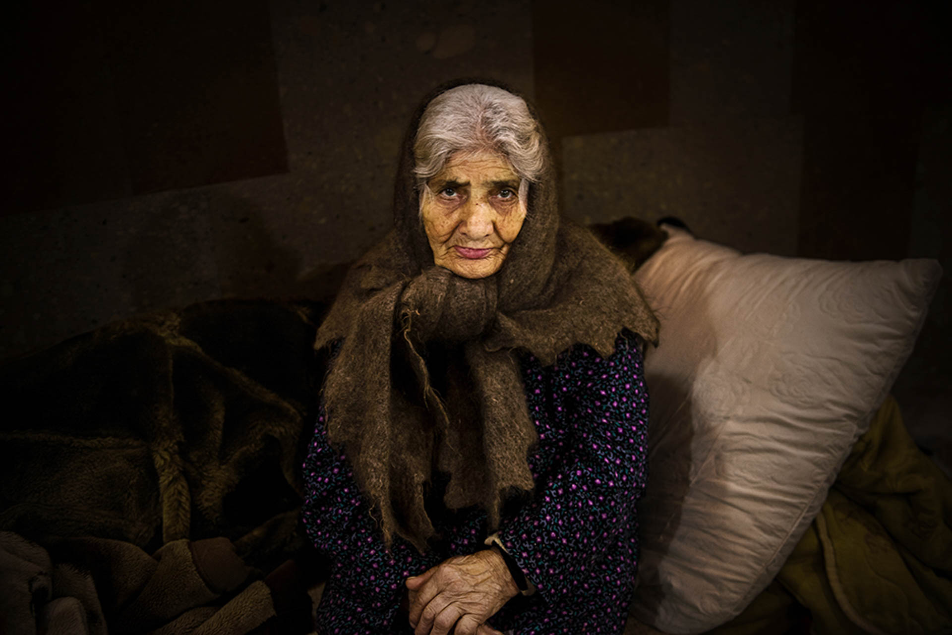  <p class='fr'>
Une grand-mère réfugiée dans le sous-sol d’une église de Stepanakert qui sert d’abri à ceux qui ont dû quitter leur région pour fuir les bombardements des forces azerbaïdjanaises.	</p> <p class='en'>

An elderly woman in the crypt of a church in Stepanakert used as a shelter for refugees who fled regions attacked by Turkish and Azeri forces.</p>