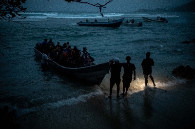 
<p class='fr'>

Un groupe d’Afghans à bord d’une embarcation en Colombie, en direction du Darién. Le capitaine aboie ses ordres et leur dit d’éteindre leurs portables pour ne pas être repérés par la police. Puis le moteur a rugi et les 54 Afghans sont partis en trombe le long de la côte, pleurant, vomissant et priant. Ils étaient nombreux à voir la mer pour la première fois.

</p>
 
<p class='en'>

A group of Afghans aboard a boat in Colombia, heading for the Darién Gap. The captain barked orders, telling them to turn off their mobile phones so they would not be detected by the police. The motor roared, and the 54 Afghans sped up the coast, crying, vomiting and praying. For many it was the first time they had seen the open sea.
</p>

